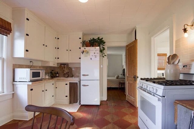 1801 N Broadway Ave, Shawnee, OK 74804 - kitchen with a sink, white appliances, backsplash, light countertops, and white cabinets