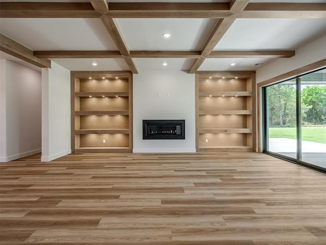 unfurnished living room featuring built in features, baseboards, light wood-type flooring, a glass covered fireplace, and recessed lighting
