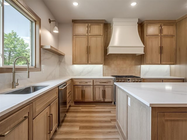 kitchen with a sink, custom range hood, open shelves, recessed lighting, and light wood-style floors
