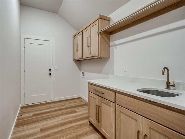 washroom with hookup for a washing machine, light wood-style flooring, baseboards, and cabinet space