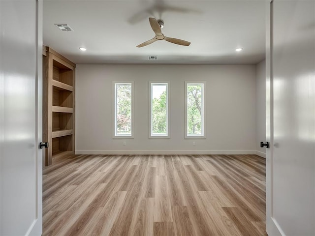 spare room with healthy amount of natural light, a ceiling fan, light wood-style floors, baseboards, and recessed lighting