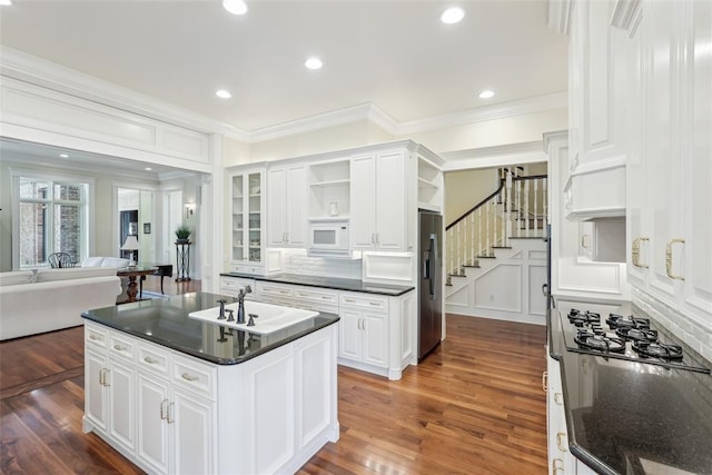 368 Millbrook Dr, Norman, OK 73072 - kitchen with white microwave, a sink, open shelves, ornamental molding, and dark wood-type flooring