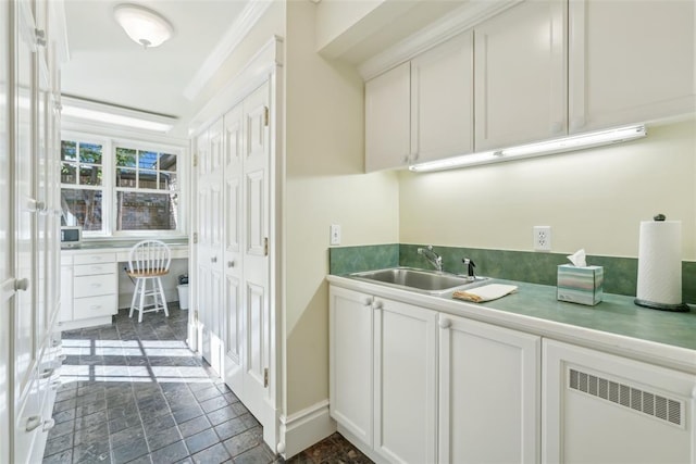 368 Millbrook Dr, Norman, OK 73072 - bar featuring stone tile floors, a sink, built in study area, radiator, and baseboards