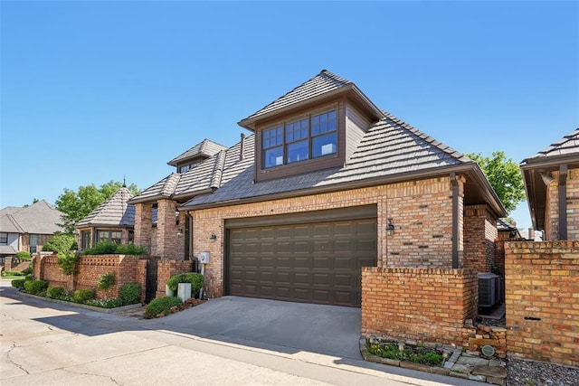 368 Millbrook Dr, Norman, OK 73072 - view of front of home featuring brick siding, a garage, concrete driveway, and central AC unit