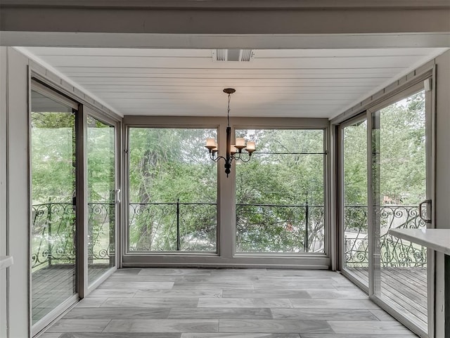 unfurnished sunroom with a chandelier