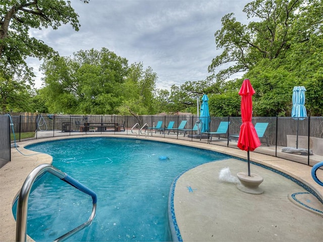 view of swimming pool featuring fence and a patio area