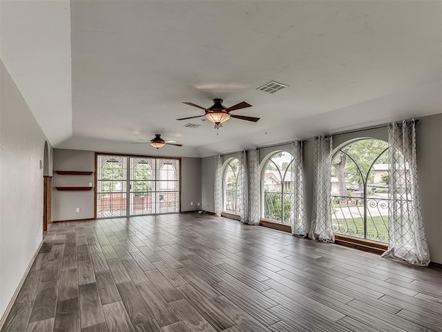 unfurnished living room with dark wood-type flooring and ceiling fan