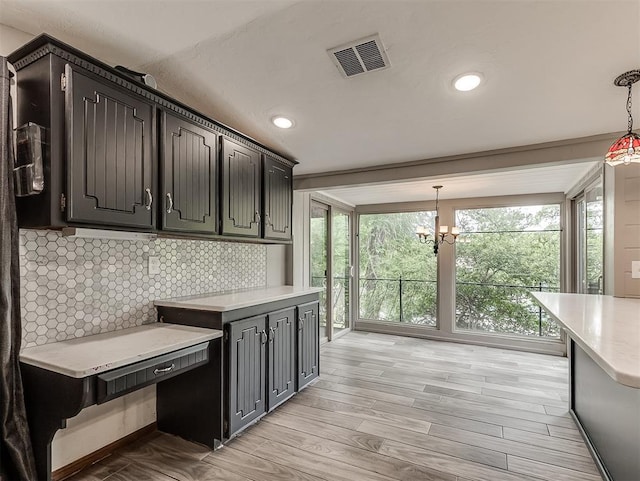 kitchen featuring light countertops, a chandelier, light wood finished floors, pendant lighting, and recessed lighting
