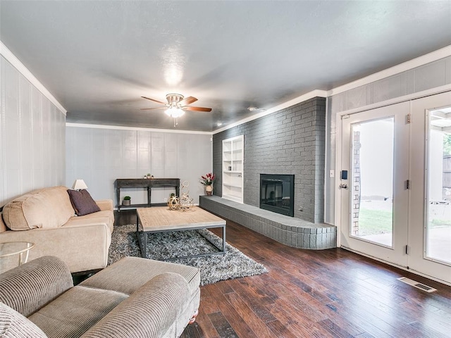 7700 Wegner Way, Oklahoma City, OK 73162 - living room featuring ornamental molding, hardwood / wood-style floors, a brick fireplace, ceiling fan, and a decorative wall