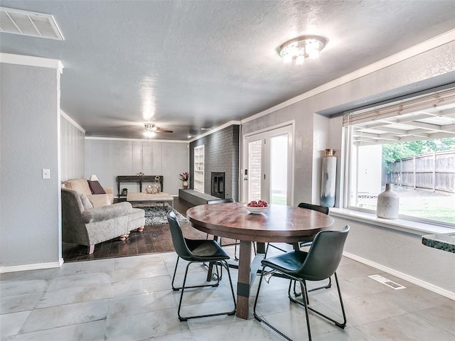 7700 Wegner Way, Oklahoma City, OK 73162 - dining room with ornamental molding, healthy amount of natural light, baseboards, a textured ceiling, and ceiling fan