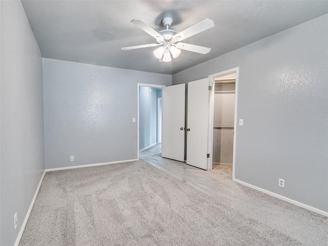 7700 Wegner Way, Oklahoma City, OK 73162 - unfurnished bedroom featuring carpet flooring, baseboards, a walk in closet, and ceiling fan