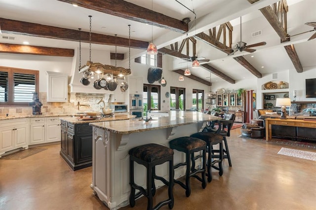 9639 Horizon Cir, Sperry, OK 74073 - kitchen featuring plenty of natural light, concrete flooring, a large island with sink, and a ceiling fan