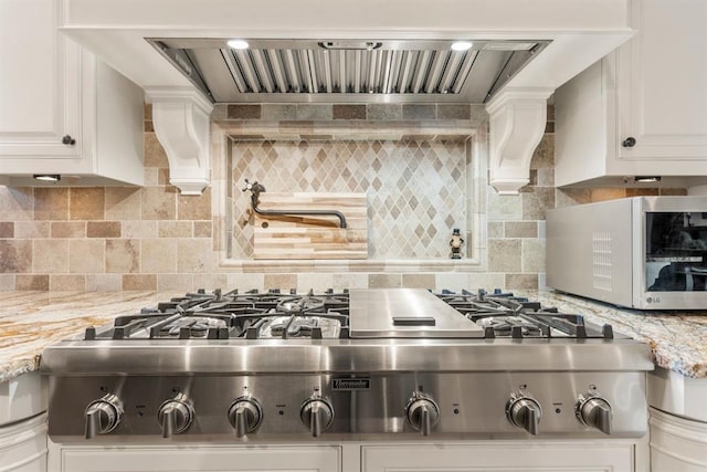 9639 Horizon Cir, Sperry, OK 74073 - kitchen featuring light stone counters, custom exhaust hood, backsplash, white cabinets, and appliances with stainless steel finishes