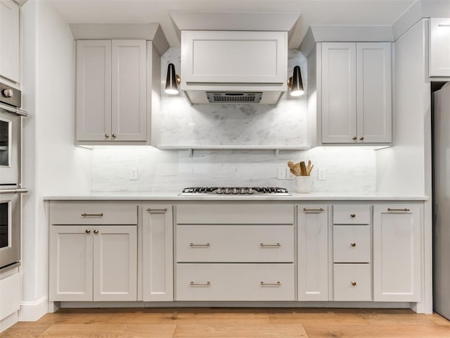 11825 Leaning Elm Rd, Oklahoma City, OK 73120 - kitchen with stainless steel appliances, decorative backsplash, light countertops, and light wood-style flooring