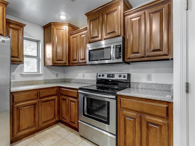 20140 N Rolling Meadows Dr, Luther, OK 73054 - kitchen featuring appliances with stainless steel finishes, brown cabinetry, light tile patterned floors, and recessed lighting