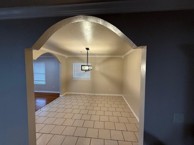 6300 S Hiwassee Rd, Oklahoma City, OK 73150 - unfurnished dining area featuring ornamental molding, arched walkways, baseboards, and tile patterned flooring