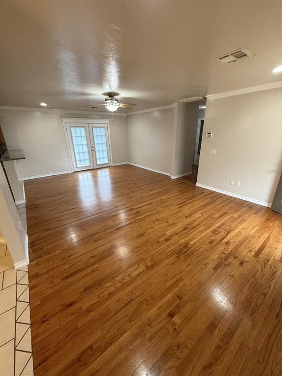 6300 S Hiwassee Rd, Oklahoma City, OK 73150 - unfurnished living room with ceiling fan, crown molding, wood finished floors, and baseboards