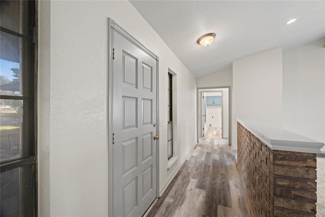 9800 Honeysuckle Rd, Oklahoma City, OK 73159 - hall featuring lofted ceiling, a textured wall, and dark wood-type flooring