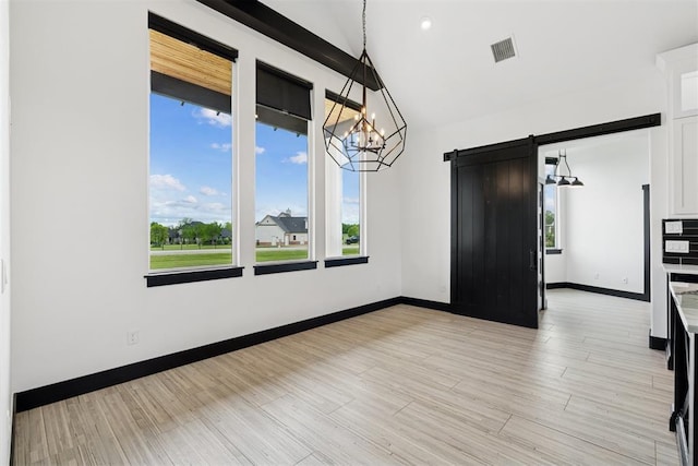 7217 Painted Sky Dr, Edmond, OK 73034 - unfurnished dining area featuring a barn door, a chandelier, baseboards, lofted ceiling, and light wood-type flooring