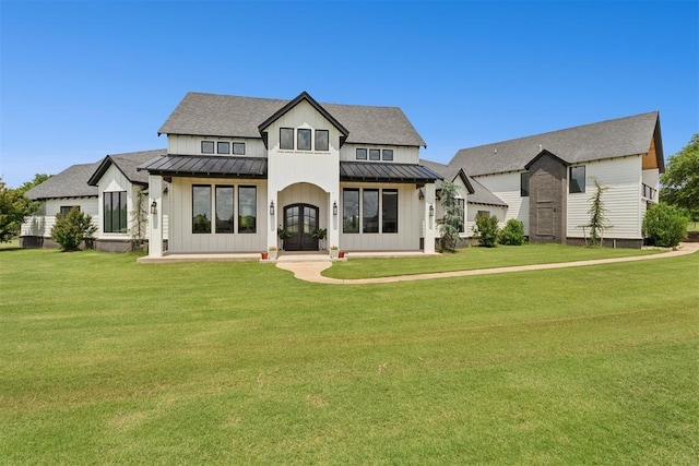 7217 Painted Sky Dr, Edmond, OK 73034 - rear view of property featuring a standing seam roof, french doors, board and batten siding, and a yard