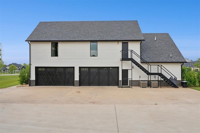 7217 Painted Sky Dr, Edmond, OK 73034 - view of front of home with an attached garage, driveway, central AC unit, and roof with shingles