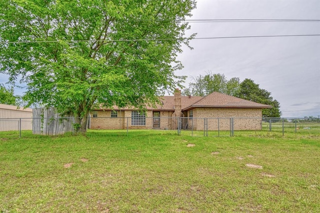 rear view of house with a yard, a chimney, and fence