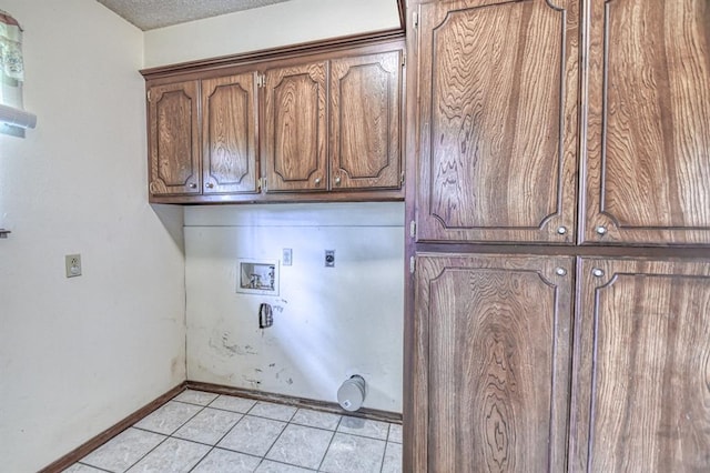laundry area with cabinet space, hookup for an electric dryer, light tile patterned floors, baseboards, and hookup for a washing machine