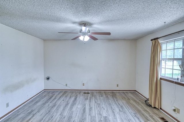 spare room featuring ceiling fan, a textured ceiling, and light wood-style floors
