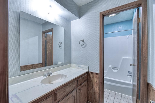 bathroom with washtub / shower combination, tile patterned floors, and vanity