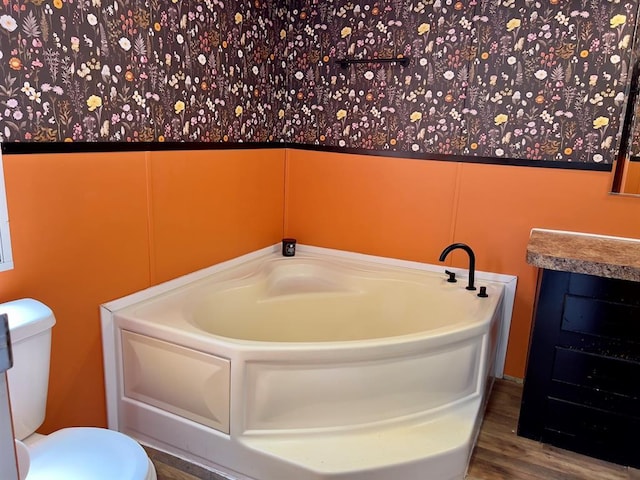 559 Poppy Rd, Broken Bow, OK 74728 - bathroom with toilet, a garden tub, and wood finished floors