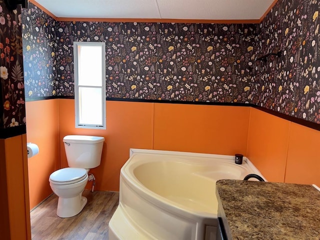 559 Poppy Rd, Broken Bow, OK 74728 - full bathroom with toilet, wainscoting, a garden tub, a decorative wall, and wood finished floors