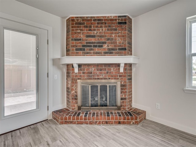 unfurnished living room featuring a fireplace and wood finished floors