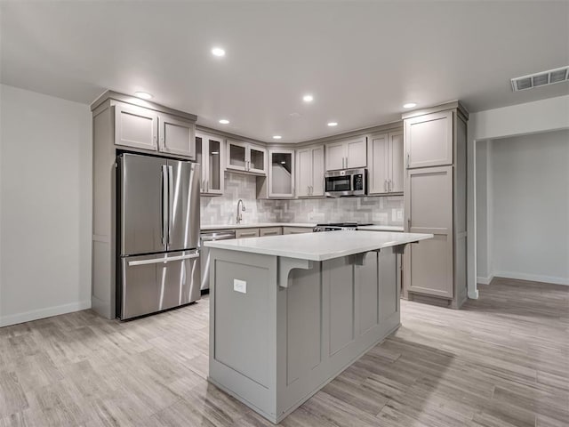 kitchen featuring appliances with stainless steel finishes, light countertops, decorative backsplash, baseboards, and recessed lighting