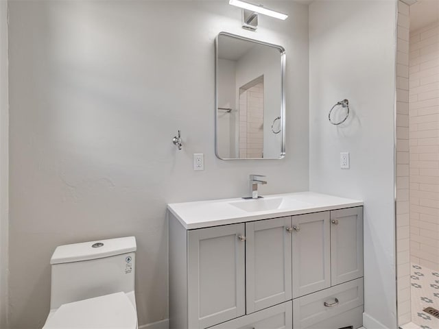 bathroom with tiled shower, toilet, and vanity