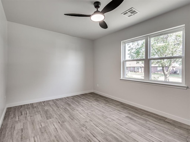 empty room with light wood finished floors, ceiling fan, and baseboards