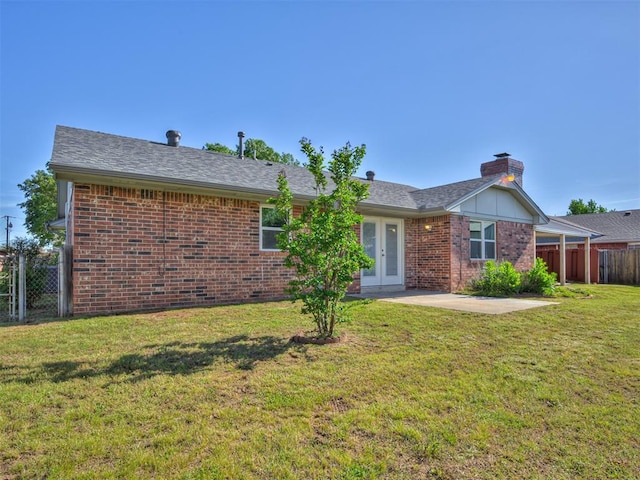 ranch-style house with french doors, a patio, brick siding, and a chimney