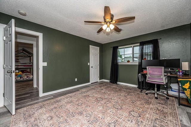 232 S Ranchwood Manor Dr, Oklahoma City, OK 73139 - office space with a textured ceiling, a ceiling fan, wood finished floors, a textured wall, and baseboards