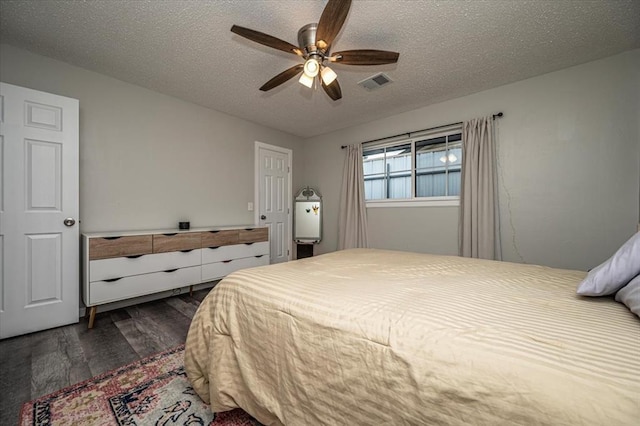 232 S Ranchwood Manor Dr, Oklahoma City, OK 73139 - bedroom with dark wood-type flooring, a textured ceiling, and a ceiling fan