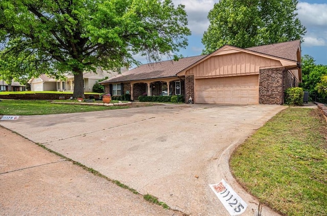 11125 NW 116th St, Yukon, OK 73099 - ranch-style house with an attached garage, brick siding, driveway, and a front lawn