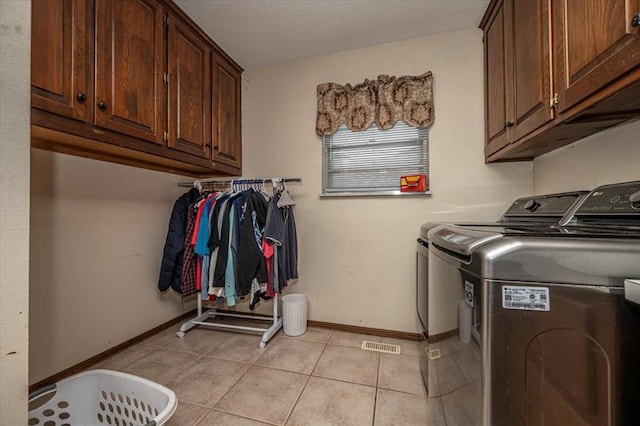 11125 NW 116th St, Yukon, OK 73099 - clothes washing area featuring cabinet space, washer and clothes dryer, light tile patterned floors, and baseboards