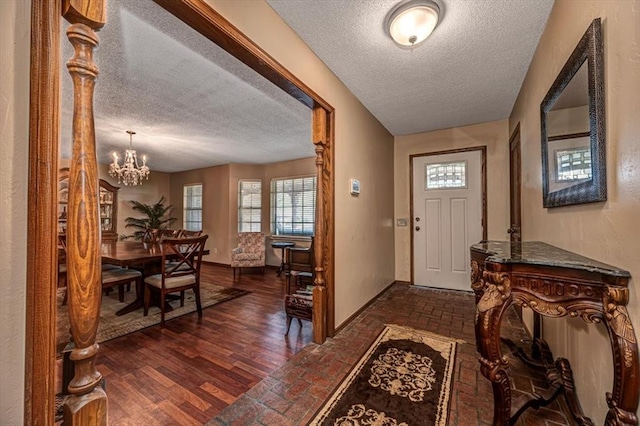 11125 NW 116th St, Yukon, OK 73099 - entrance foyer featuring a textured ceiling, a chandelier, brick floors, and baseboards