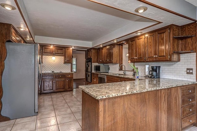 11125 NW 116th St, Yukon, OK 73099 - kitchen featuring stainless steel appliances, a sink, decorative backsplash, light tile patterned floors, and light stone countertops