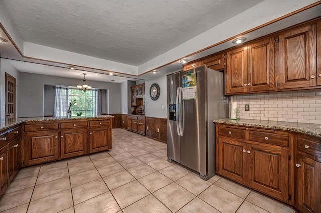 11125 NW 116th St, Yukon, OK 73099 - kitchen with stainless steel fridge with ice dispenser, a chandelier, a textured ceiling, wainscoting, and brown cabinets