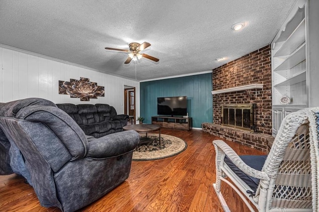 11125 NW 116th St, Yukon, OK 73099 - living area with a ceiling fan, wood finished floors, a textured ceiling, and a fireplace