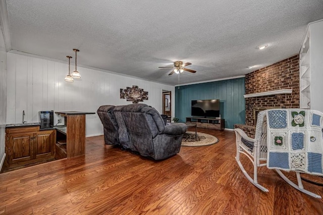 11125 NW 116th St, Yukon, OK 73099 - living area featuring a textured ceiling, ceiling fan, wood finished floors, and a fireplace