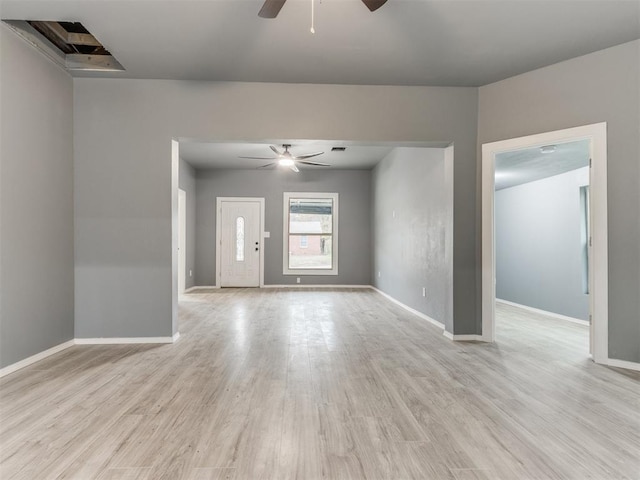 spare room with baseboards, light wood-style flooring, and ceiling fan