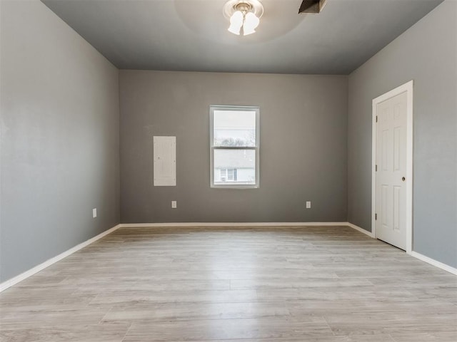 unfurnished room with baseboards and light wood-type flooring