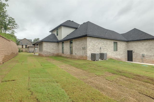 6516 NE 97th St, Oklahoma City, OK 73151 - view of side of property featuring a shingled roof, a lawn, and brick siding