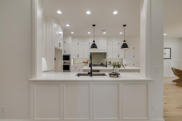 6516 NE 97th St, Oklahoma City, OK 73151 - kitchen featuring a peninsula, white cabinets, stainless steel appliances, decorative backsplash, and light countertops
