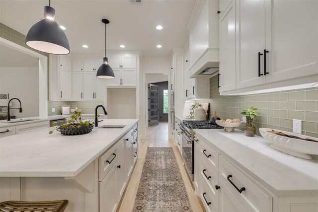 6516 NE 97th St, Oklahoma City, OK 73151 - kitchen featuring stainless steel range, premium range hood, decorative backsplash, white cabinetry, and light stone countertops